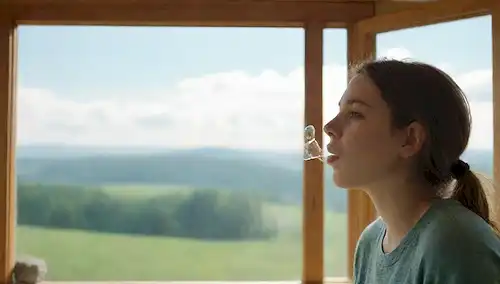 Una persona soplando burbujas con un fondo tranquilo, pulmones o vías respiratorias ilustración en colores suaves, algunas nubes blancas suaves, un gradiente sutil que pasa de azul a verde, un toque de luz filtrando a través de una ventana, texturas naturales como madera o piedra