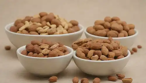 3 tazones o placas con fondo neutro, lleno de una mezcla de nueces, algunos en estado crudo y otros asados, dispuestos a ilustrar la comparación