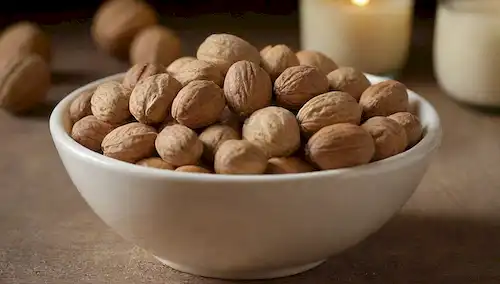 Un tazón o plato con una selección de nueces (nogallas, almendras y avellanas) dispuestas artísticamente, con algo ligeramente suelto; fondo podría ser una madera de tono cálido o color beige; la iluminación es suave y natural; sensación general es rústico e invitando