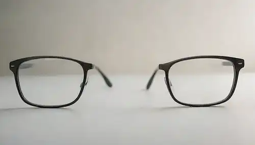 2 pares de lentes con diferentes diseños de lentes y niveles de prescripción, uno para visión cercana y otro para distancia, con un efecto sutil gradiente para transmitir lentes progresivas, configurados en un fondo blanco o de color claro