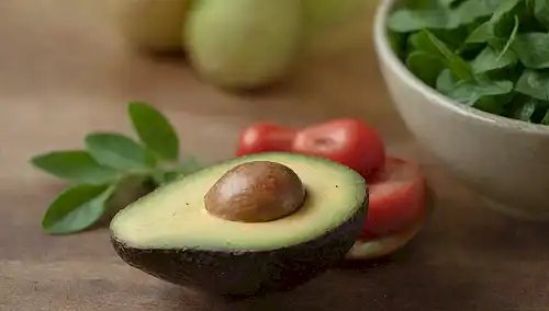 Un aguacate maduro, un tazón con tenedor y cuchara, colores vibrantes, verdes frescos, un ambiente cálido, un entorno rústico, un fondo simple, iluminación suave, texturas naturales, algunos elementos decorativos, un sentido de abundancia