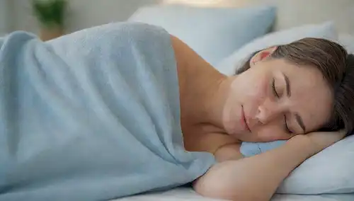 Una persona que duerme tranquilamente en una cama con compresas frías envueltas alrededor de su cuerpo, rodeada de colores de fondo calma como azules suaves y blancos, iluminación suave sin sombras duras, texturas sutiles como sábanas suaves y mantas suaves, expresión facial relajada y ligera sonrisa