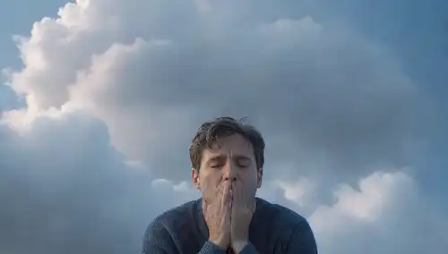 ilustración 3D de una persona de aspecto cansado rodeada de nubes, con una luz débil en el fondo, que representa un sentido de agotamiento, fatiga y cansancio; un brillo sutil alrededor de la persona sugiere esperanza de cambio; los colores se mutilan, con tonos de azul y gris dominante para transmitir sentimientos de cansancio