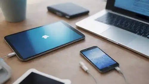 Ilustración 3D de un iPhone reformado en una mesa, con un ordenador portátil o tableta en el fondo que muestra pantallas de mercado en línea, rodeado de accesorios y cables de smartphone dispersos, con un sutil gradiente de colores azul y blanco