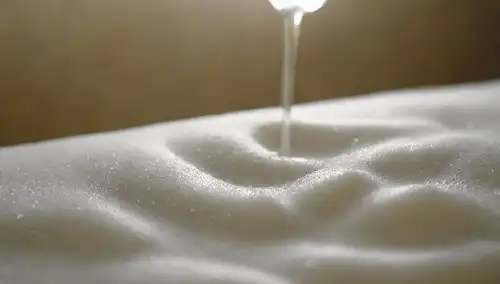 una delicada prenda que se limpia suavemente con jabón líquido, burbujas suaves que la rodean, flujo suave de agua fluye hacia abajo, espuma sutil girando alrededor, calmante y ambiente sereno, fondo minimalista, enfoque suave en la tela