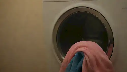 ropa, alta temperatura, lavadora, subida de vapor, ropa temblando, colores vibrantes, telas sin arrugas, prendas relajadas, texturas suaves, y un resplandor cálido