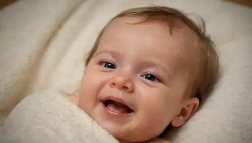 Una fotografía de tono cálido de un bebé feliz