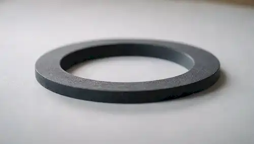 Una toma de cerca de una máquina de lavado limpia, sin manchas ni residuos; la superficie de las juntas es lisa y libre de suciedad, con un recubrimiento sutil; el enfoque suave destaca en las crestas y la textura de la junta de gas; una profundidad poco profunda de campo para enfatizar el propio gasket; un simple fondo blanco o de color claro;