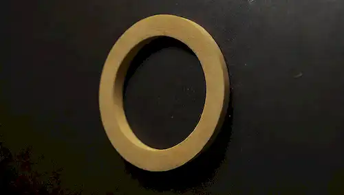 un empaquetado de goma gastado con manchas de lecho, una inyección de cierre, foco suave, iluminación caliente, acumulación de grime, crecimiento de molde negro, residuos de jabón, lavadora sucia, textura borrosa, color marrón amarillo
