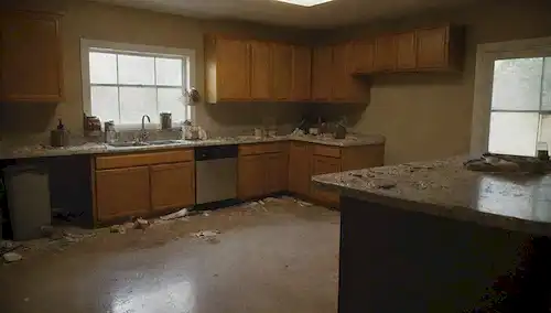 Una cocina desordenada con migas y derrames en encimeras, latas de basura abiertas, superficies pegajosas cerca de áreas de preparación de alimentos, contadores desordenados con platos sucios y utensilios, esquinas oscuras con polvo y acumulación de suciedad