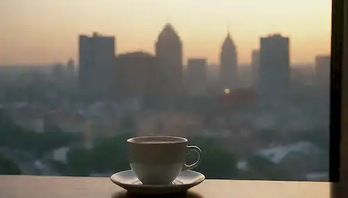 Reloj las 24 horas con escenas de la mañana y de la noche, una persona que duerme tranquilamente, un paisaje urbano al atardecer, una taza de café, una cálida luz, un suave amanecer, un ambiente relajante, una calle tranquila, una rutina de la mañana