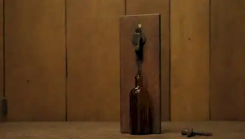 2 bisagras de puertas viejas con textura oxidada, gotas de aceite de ellos, una pequeña botella de aceite usado reciclado cerca, una creación DIY creativa alrededor de ella, iluminación amarilla cálida, fondo de madera, tal vez algunas herramientas dispersas o materiales