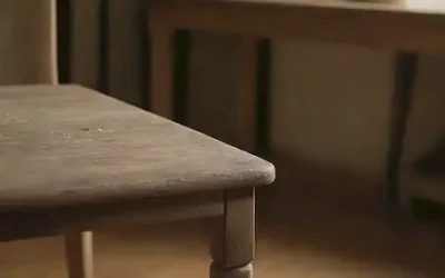 Una silla de madera desgastada con rasguños y manguitos