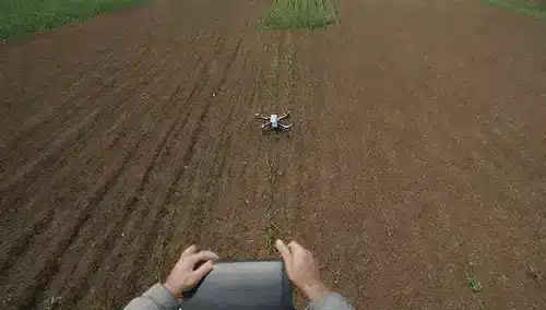 un campo con cultivos de diferentes colores y alturas, un agricultor inspeccionando una planta a la distancia, un drone volando arriba para capturar datos, sensores de suelo dispersos alrededor, sistema de riego de precisión, un tractor equipado con la tecnología moderna de conducción por, un agricultor mirando una tableta que muestra analítica