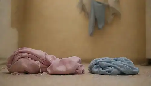 Un par de desgaste atlético con bordes frayed, colores decolorados y hilos sueltos colgando, junto a un montón de ropa fresca y crujiente en un piso limpio, rodeado de pistas de una habitación desordenada, transportando desarray y descuido, con un aire de ambiente de estancamiento